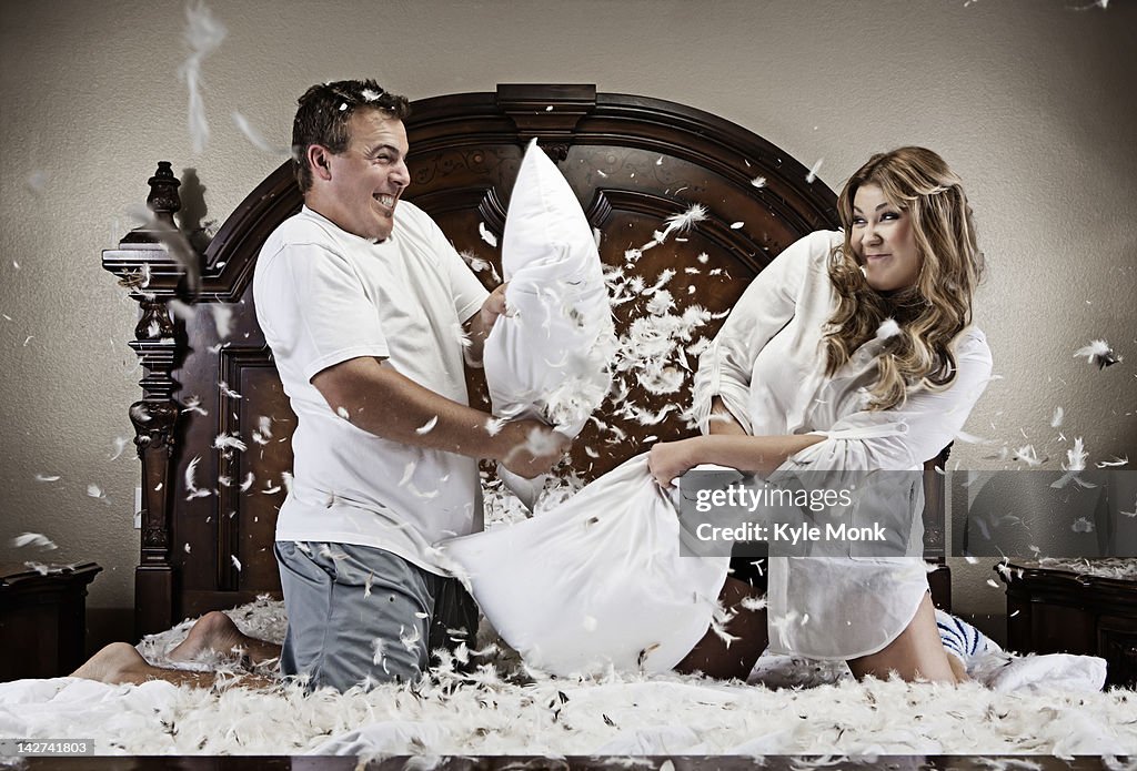 Caucasian couple having pillow fight
