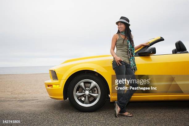 chinese woman standing near convertible at beach - lean imagens e fotografias de stock