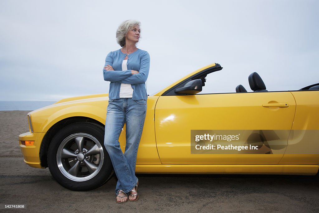 Caucasian woman leaning on convertible