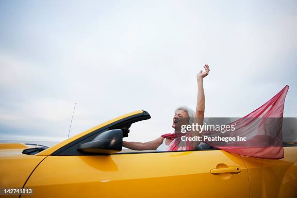 caucasian woman driving yellow convertible - sports car stock pictures, royalty-free photos & images