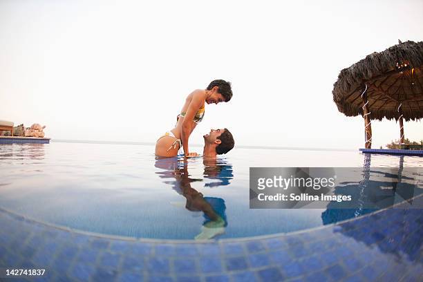 hispanic couple enjoying swimming pool - rooftop pool stock pictures, royalty-free photos & images