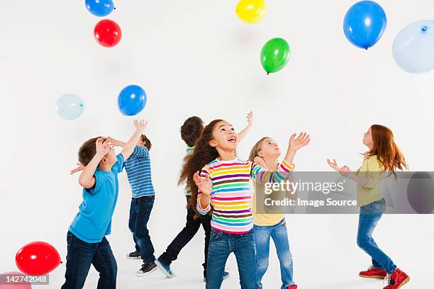 children playing with balloons - child balloon studio photos et images de collection