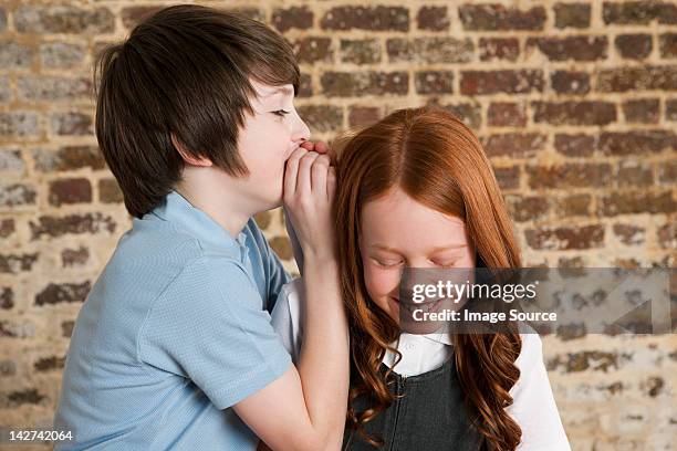 boy whispering to girl - embarrassed girlfriend stock pictures, royalty-free photos & images