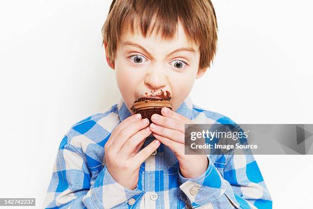 boy devouring a cupcake - eating cake stock pictures, royalty-free photos & images