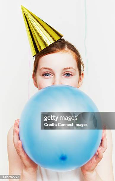 girl in party hat, blowing up balloon - inflating ストックフォトと画像