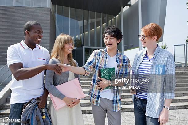 university students talking at campus - international student day stock-fotos und bilder