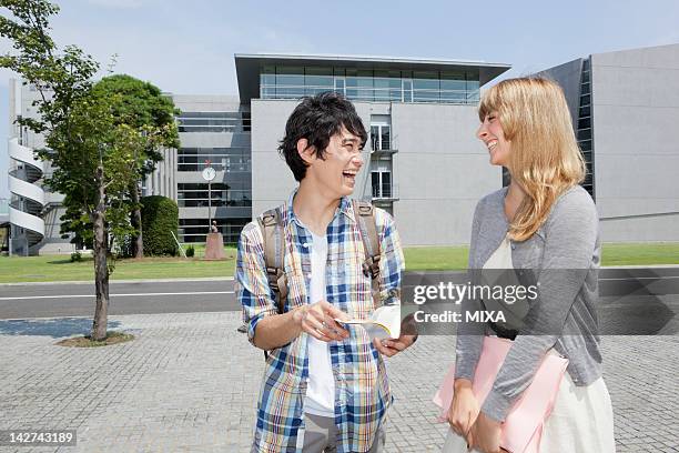 university students talking at campus - international student day stock-fotos und bilder