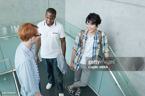 university students talking on stairs - international student day stock-fotos und bilder
