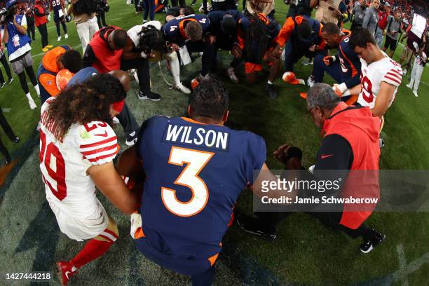 Denver Broncos and San Francisco 49ers players pray together after their game at Empower Field At Mile High on September 25, 2022 in Denver, Colorado.