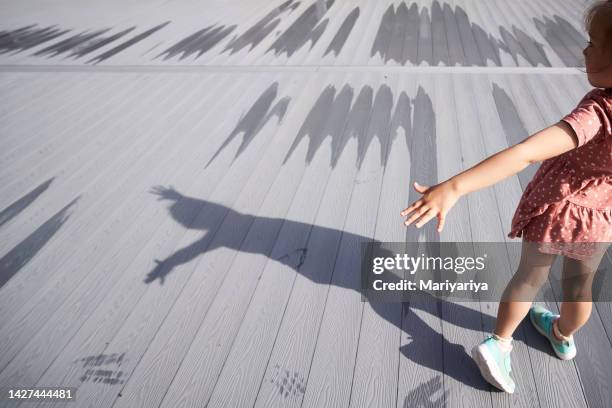 shadows of a girl on a gray wooden veranda. - sombra en primer plano fotografías e imágenes de stock