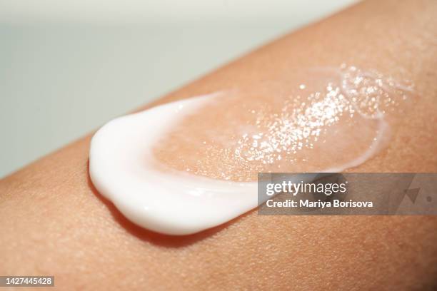 white cream texture on women's skin. - suncream stock pictures, royalty-free photos & images