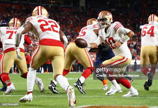 Jimmy Garoppolo hands off to Jeff Wilson Jr. #22 of the San Francisco 49ers during the second half against the Denver Broncos at Empower Field At...