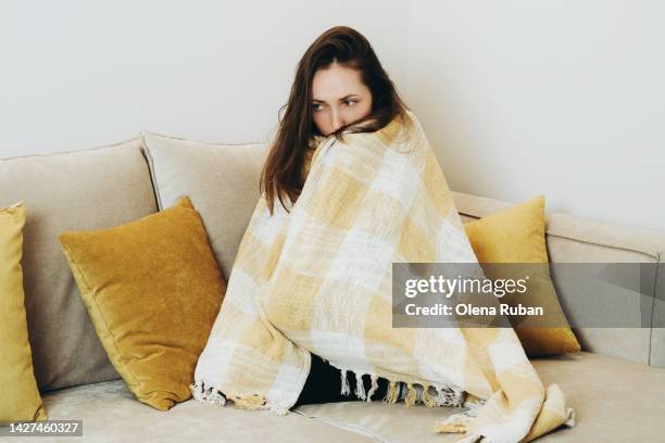 frozen young woman wrapping in plaid. - winter illness stock pictures, royalty-free photos & images