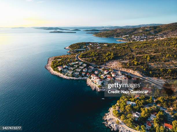 adriatic highway running alongside the sea with luxury village alongside at sunset - adriatic sea stock pictures, royalty-free photos & images