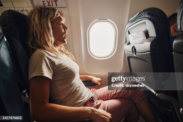 fearful woman traveling by airplane. - pressure airplane stock pictures, royalty-free photos & images