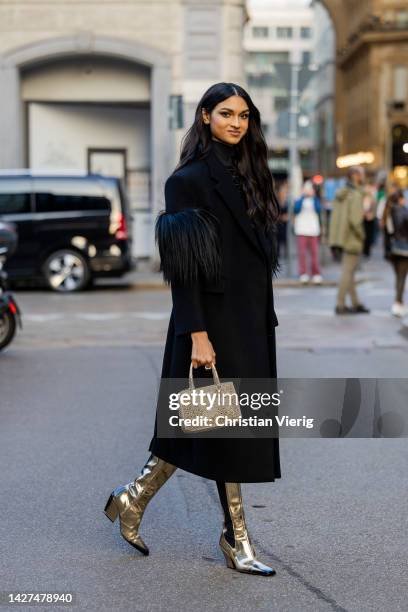 Kiara Nirgin wears black Prada coat, turtleneck Prada, golden bag Prada, golden varnished boots outside CNMI Sustainable Fashion Awards during the...