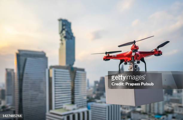 drones carry express packages in city - unmanned aerial vehicle stock pictures, royalty-free photos & images