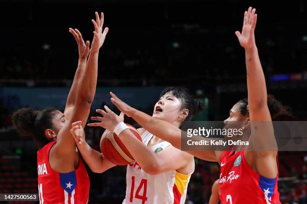 Yueru Li of China drives to the basket against Brianna Jones of Puerto Rico and Jennifer O'Neill of Puerto Ricoduring the 2022 FIBA Women's...