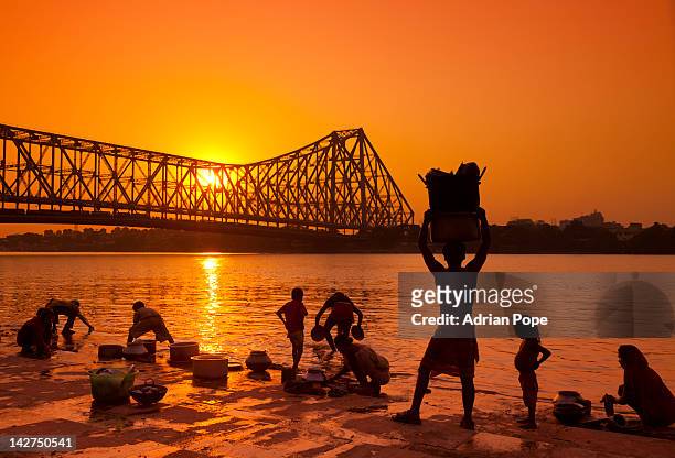 familes washing in hooghly river, calcutta - howrah bridge stock pictures, royalty-free photos & images