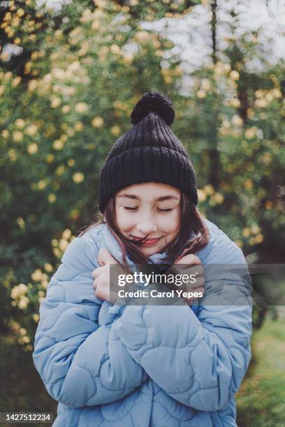 front view portrait of girl in winter clothes embracing herself - self-love stock pictures, royalty-free photos & images