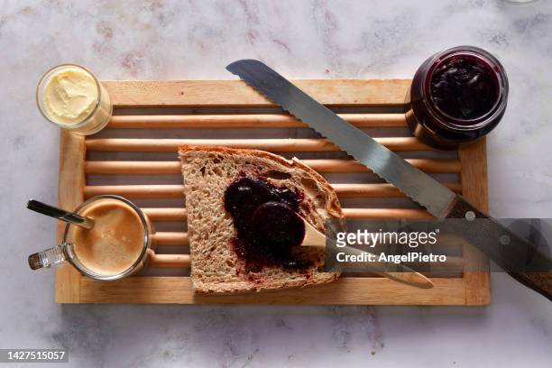 still life with the elements of a breakfast: slice of bread, butter and blackberry jam. - rebanada bildbanksfoton och bilder