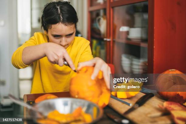 girl carving face in halloween pumpkin - halloween stencil stock pictures, royalty-free photos & images