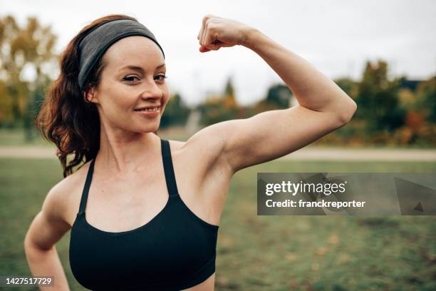 fitness woman showing the muscle - arm flexing stockfoto's en -beelden