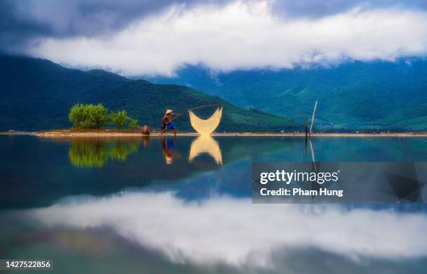 fisherman in lap an lagoon - vietnam strand stock pictures, royalty-free photos & images