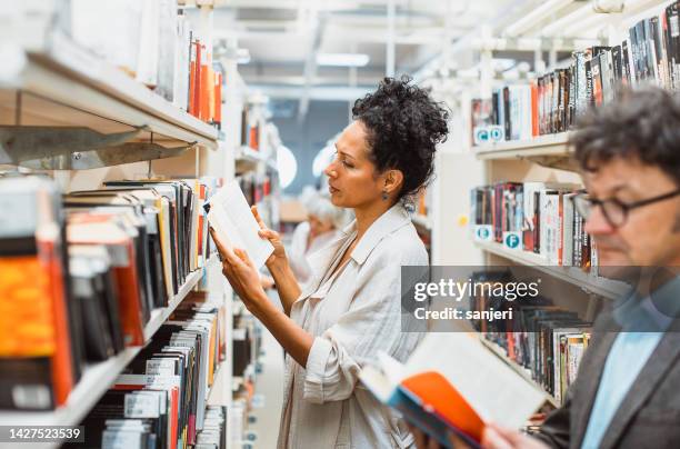 kleine gruppe von leuten in der bibliothek - librarian stock-fotos und bilder