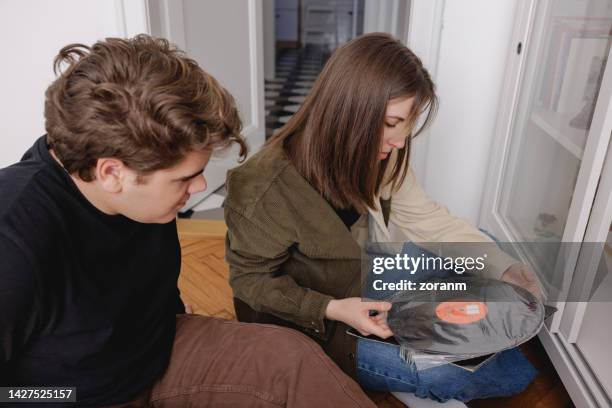two teenagers sitting at home and opening old vinyl records - teen packing suitcase stock pictures, royalty-free photos & images
