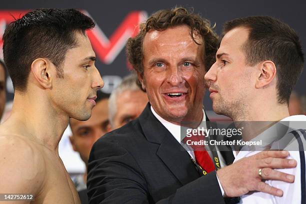 Felix Sturm of Germany and Sebastian Zbik of Germany look eye to eye and Thomas Puetz, president of the German Boxing Association controls them after...