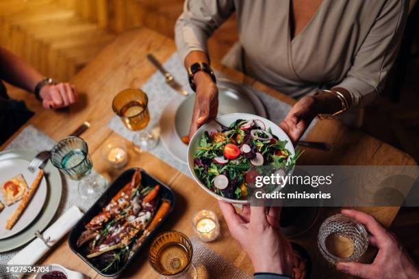 unrecognizable friends and family sharing food at dinning room - conference dining table stock pictures, royalty-free photos & images