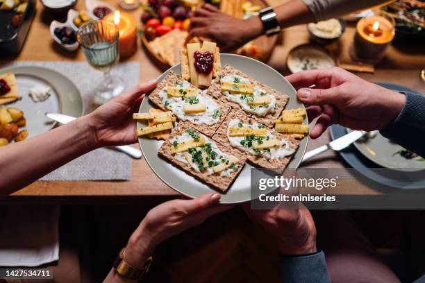 unkenntliche freunde und familie, die essen im speisesaal teilen - knäckebrot stock-fotos und bilder