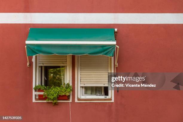 two windows with one awning - awning window fotografías e imágenes de stock