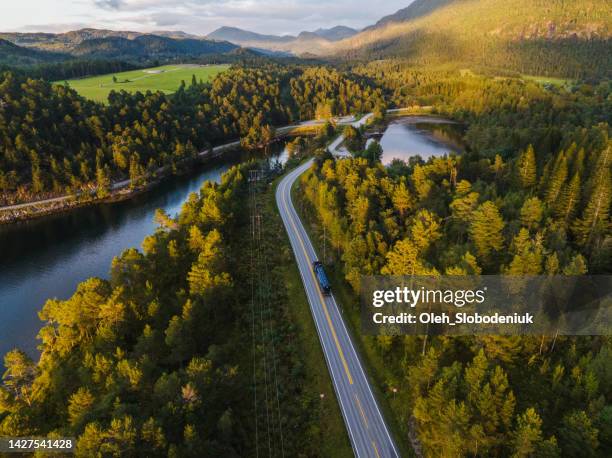 scenic aerial view of truck on the road through norwegian highlands - finnish nature stockfoto's en -beelden