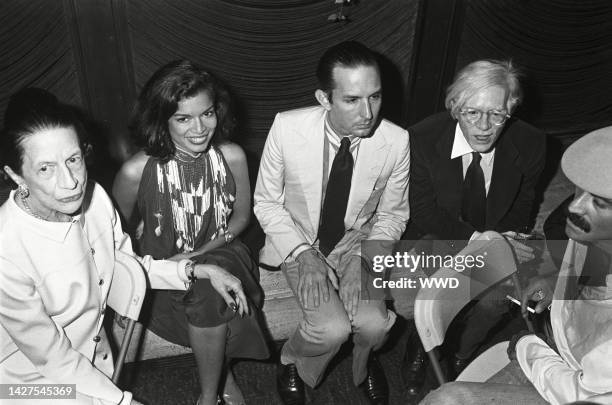 Diana Vreeland, Bianca Jagger, Fred Hughes, Andy Warhol, and Victor Hugo seated and talking at a party at The Four Seasons hotel in New York for the...