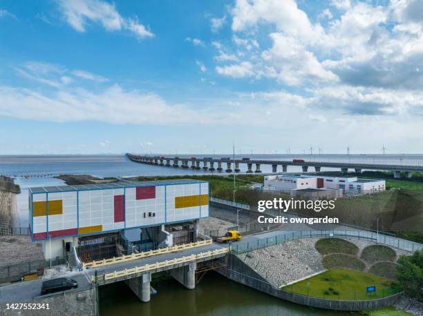 large sea lock with dike seen from the air with donghai bridge and sea in background - polder barrage photos et images de collection