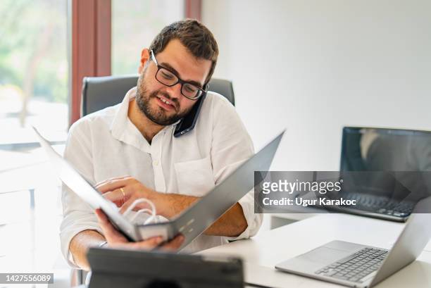 young businessman examining document folder at his desk - personal organizer bildbanksfoton och bilder