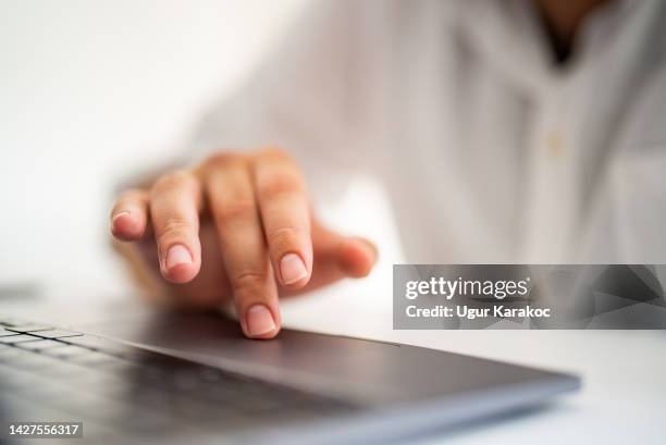 man's finger touching laptop touchpad - touchpad stock pictures, royalty-free photos & images