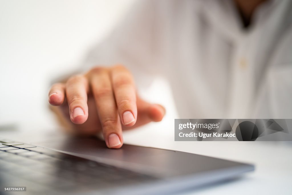 Man's finger touching laptop touchpad