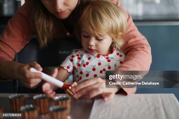 a 2 year old girl cooking with her mum in the kitchen - biscuit france stock pictures, royalty-free photos & images