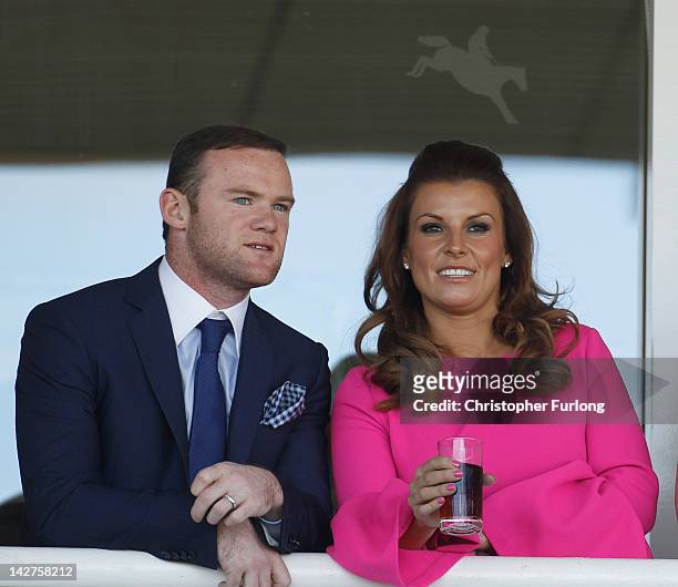 Manchester United football player Wayne Rooney and his wife Coleen watch the racing during the first day of the Aintree Grand National meeting on...