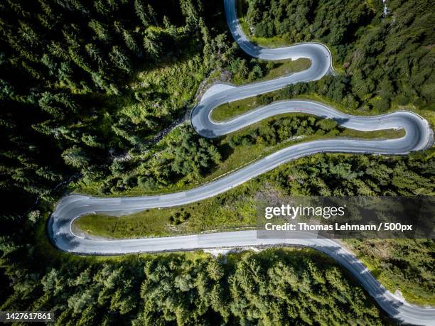 aerial view of winding road amidst trees in forest,imst,tirol,austria - curvy road stock-fotos und bilder