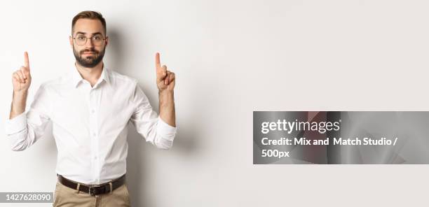 young bearded businessman pointing fingers up,showing promo offer - baby logo stock pictures, royalty-free photos & images