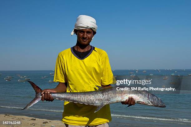 fisherman holding fish in hand - gwadar 個照片及圖片檔