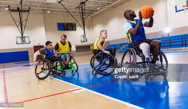 four multiracial men playing wheelchair basketball - wheelchair basketball team stock pictures, royalty-free photos & images