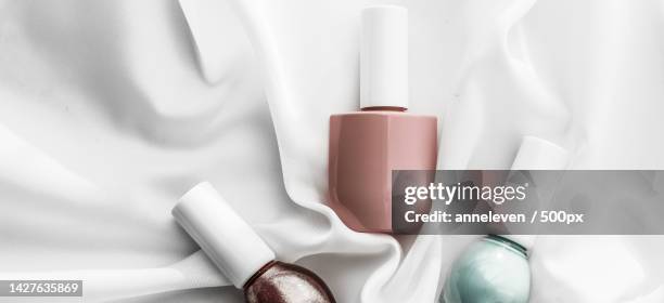 nail polish bottles on silk background,french manicure products and - french manicure stockfoto's en -beelden