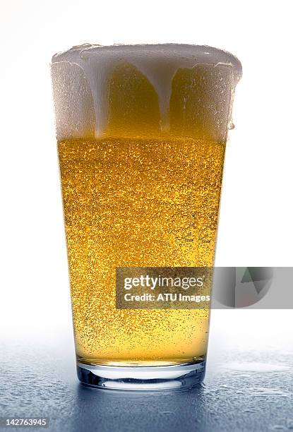 glass of cold beer - overflowing beer stock pictures, royalty-free photos & images