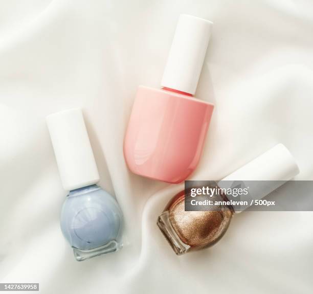 nail polish bottles on silk background,french manicure products and - flatlay fashion stockfoto's en -beelden