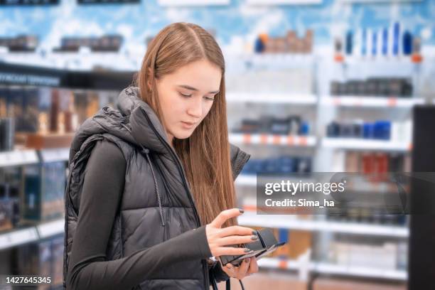 teenager gitl shopping in a cosmetics store - cosmetics shopping stock pictures, royalty-free photos & images